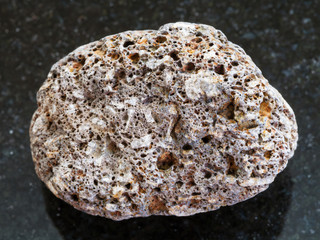 pebble of brown pumice stone on dark background
