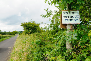 Religious sign nailed to a tree by a country lane.  