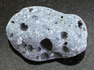 pebble of gray pumice stone on dark background