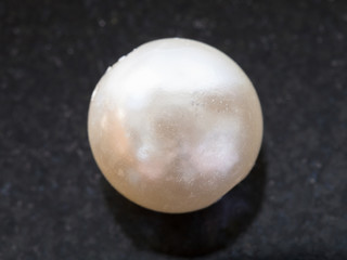 bead from white Pearl gemstone on dark