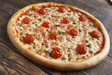 Big pizza on a wooden surface. Selective focus