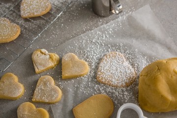 Raw heart shape cookies with sugar icing on wax paper