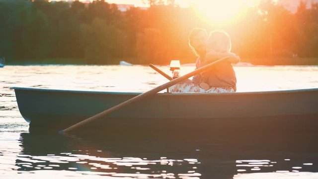 Hugging couple in a boat at sunset