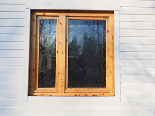 wooden window on white siding background