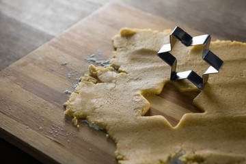 Raw cookie dough with star shape and cutter