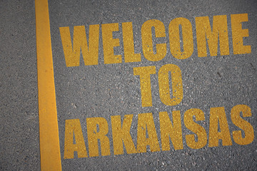 asphalt road with text welcome to arkansas near yellow line
