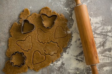Gingerbread dough with flour, cookie cutter and rolling pin