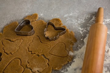 Gingerbread dough with flour, cookie cutter and rolling pin