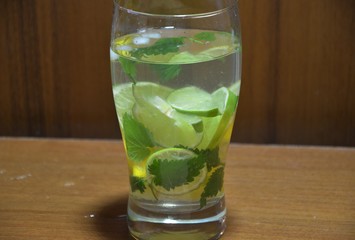 Mojito cocktail with lime and mint in highball glass on a wooden stone background Copy space