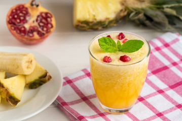 Pineapple smoothie with mint and pomegranate seeds.