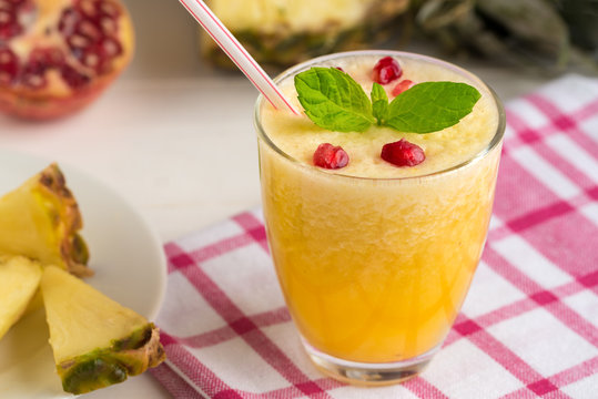 Pineapple smoothie with mint and pomegranate seeds.