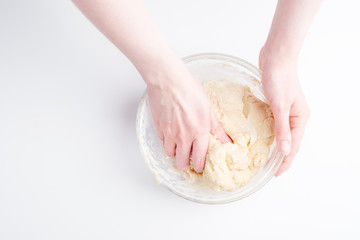Making dough by female hands on white table