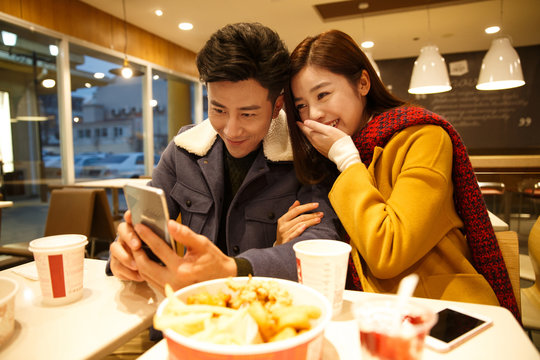 Young man showing picture to woman in the  restaurant