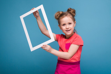 Beautiful cute little girl in pink dress holds picture frame