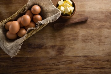 Brown eggs and cheese cubes on a wooden table