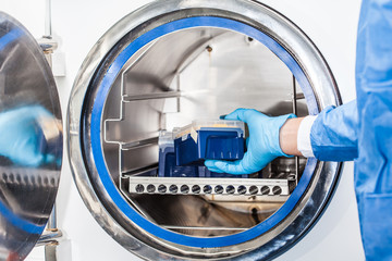 Sicentist sterilizing laboratory material in autoclave