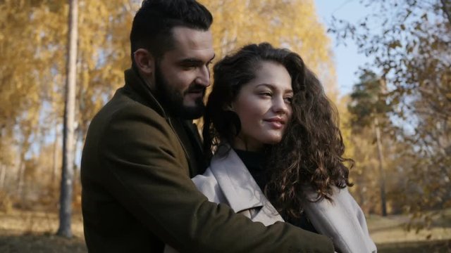 Man hugging woman in autumn park