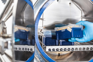 Fototapeta na wymiar Sicentist sterilizing laboratory material in autoclave