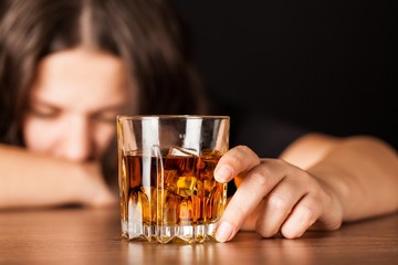 Drunk Woman Sleeping At Bar Counter Holding a Glass of Whisky