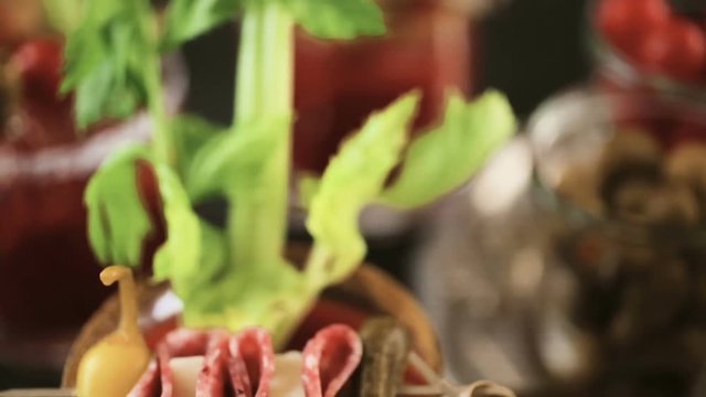 Bloody mary cocktail garnished with celery sticks, olives, and bacon strips