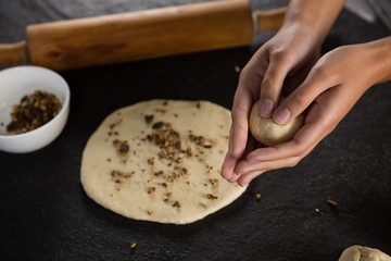 Woman rolling a dough ball in her hand