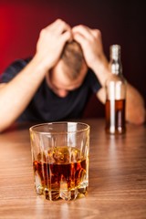 Drunk / Sad Man with Bottle and Glass of Liquor At Bar Counter