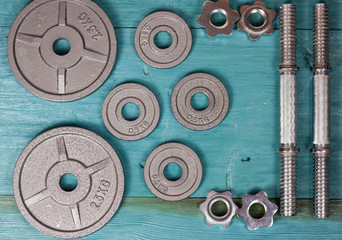 Top view of accessories for fitness in grey tone. Dumbbells, weight plates.