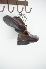 Pair of shoes hanging on hook