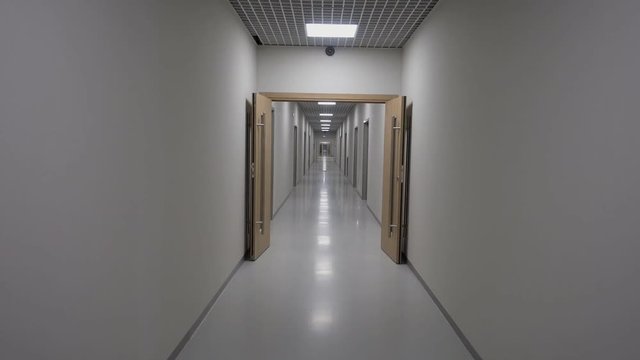 POV walking in a long white empty corridor interior