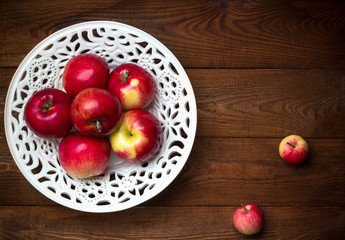 Ripe fresh red apples on bowl. wooden background. Free space for text . Top view Flat lay