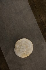 Fototapeta na wymiar Dough ball pressed on butter paper