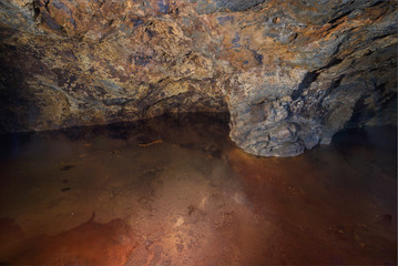 Interior of an old Pyrite mine, a red mineral toned lake has been formed in the foreground, La Union, Murcia, Spain