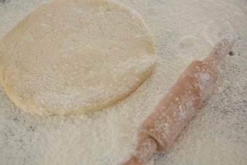 Flattened dough sprinkled with flour on a wooden table