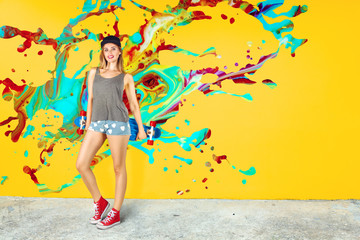 Obraz na płótnie Canvas Beautiful young woman with skateboard