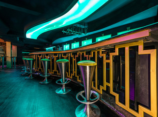 Lightening bar counter and stools in discotheque interior