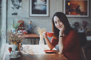 Asian woman drinking coffee in coffee shop cafe