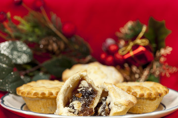 Broken mince pie on a plate with some christmas decorations