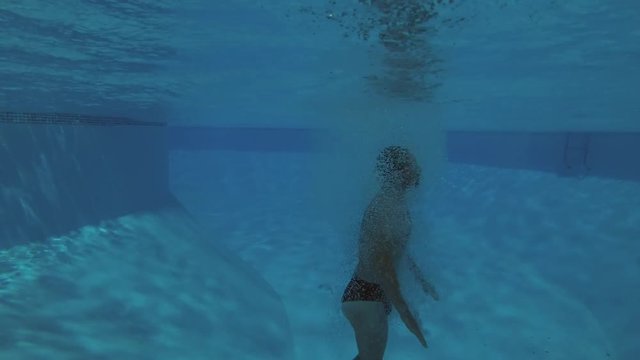 a man jumps into the pool - underwater shot
