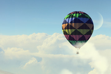 Aerostat floating in day sky. Mixed media