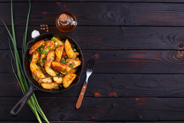 Appetizing countryside homemade meals. Roasted potatoes on dark wooden table, flat lay. Home food close up