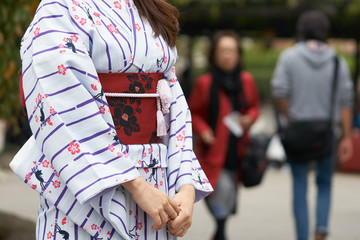 Young girl wearing Japanese kimono standing in front of Sensoji Temple in Tokyo, Japan. Kimono is a Japanese traditional garment. The word "kimono", which actually means a "thing to wear"