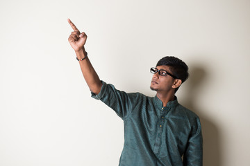 teenage indian male in traditional dress pointing somewhere