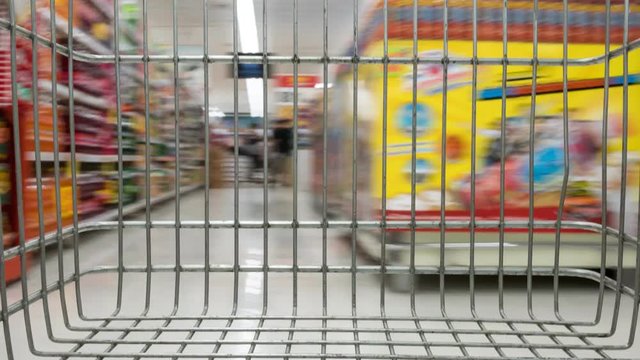 shopping cart in supermarket moving through, time lapse