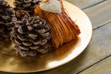 High angle  view of pine cones with thread in plate