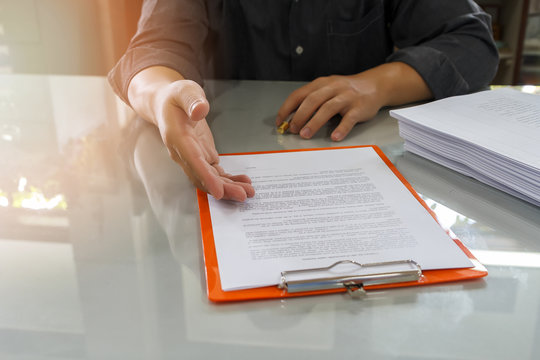 Businessman offering contract paper to his business partner for sign contract