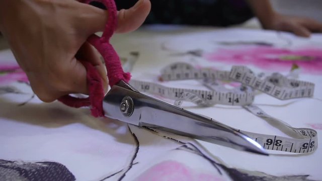 Woman hands cutting fabric with scissors