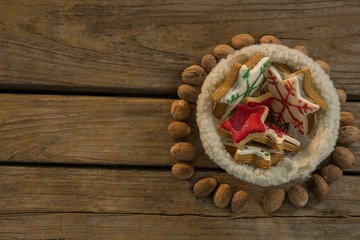 Overhead view of star shape cookies in bowl amidst walnuts