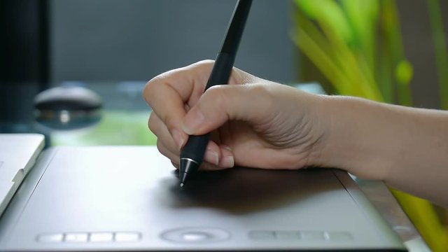 Tablet and pen .Woman working with tablet and pen for post production .