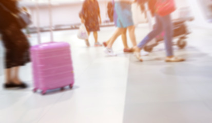 motion blurred group of travelers walking with a luggage at airport terminal, travel and adventure concept