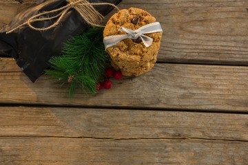 View of cookies with pine needles and cheeries by plastic bag on